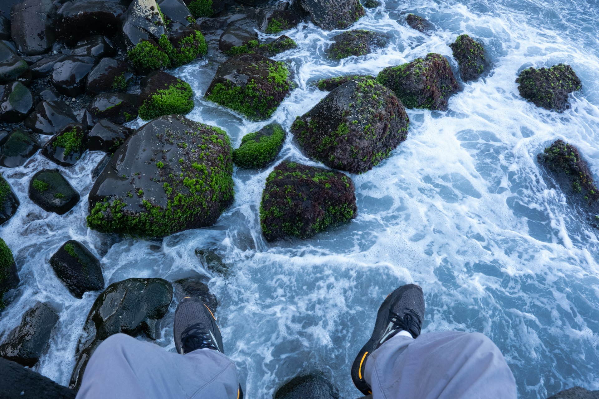 Person sitting on rocks by the ocean